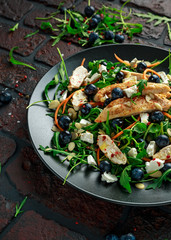 Fresh Chicken salad with Blueberries, feta, carrots, nuts and green vegetables. healthy food concept