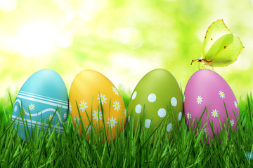 Bunt bemalte Ostereier im Gras mit Schmetterling