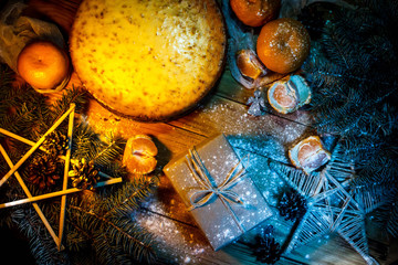Fototapeta na wymiar Cheese cake against wooden background with oranges, gift box and christmas decoration.