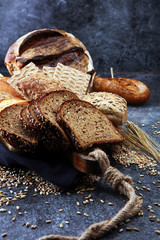 Sliced rye bread on cutting board. Whole grain rye bread and rolls with seeds.