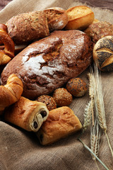 Different kinds of bread and bread rolls on burlap sack. Kitchen or bakery poster design