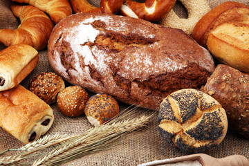 Different kinds of bread and bread rolls on burlap sack. Kitchen or bakery poster design
