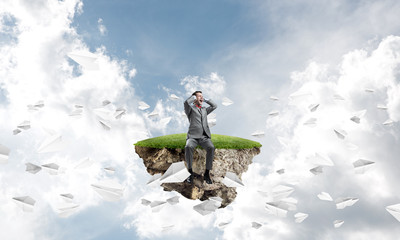 Obraz premium Young man in sky dont want to hear anything and paper planes fly around