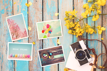 Retro camera and paper photo album on wood table with flowers border design - concept of remembrance and nostalgia holiday in spring. vintage style - obrazy, fototapety, plakaty