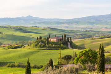 Rural view over a valley with fields and house on a hill