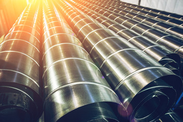Stack of steel or metal pipes or round tubes as industrial background with perspective and sunshine...