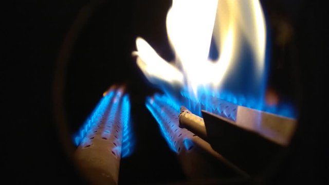 gas burners in the boiler burning bright blue and yellow flame