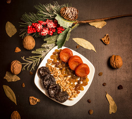 Prunes, prunes and dried apricots on black table, fruits background