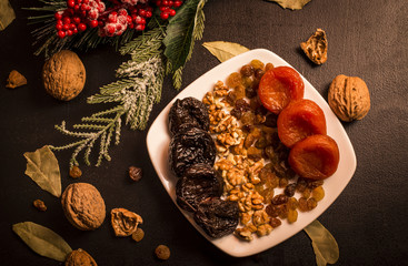 Prunes, prunes and dried apricots on black table, fruits background