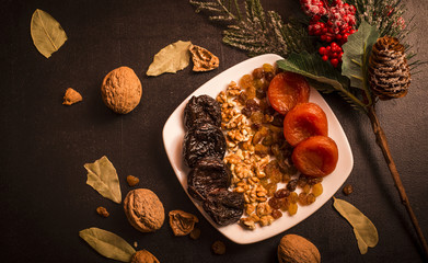 Prunes, prunes and dried apricots on black table, fruits background