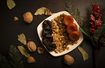 Prunes, prunes and dried apricots on black table, fruits background
