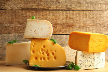 Different kinds of delicious cheese on table