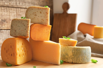 Different kinds of delicious cheese on table