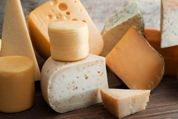 Different kinds of delicious cheese on table