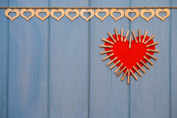 Red paper Heart of love with clips on blue wooden background. Romantic symbol. Love concept