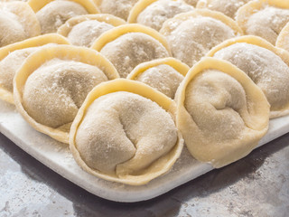 Traditional Russian handmade dumplings frozen on the board. Russian pelmeni. Ravioli
