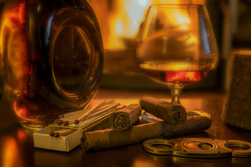 Time to enjoy! Quality cigars and cognac on a wooden table and other accessories such as cigar...