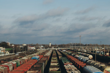 Fototapeta na wymiar A lot of freight rail cars, a cargo distribution station. Staging post. Large parking of trains.