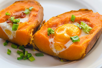 Baked sweet potato with fried egg, bacon and chives.