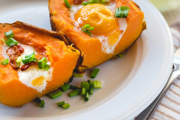 Baked sweet potato with fried egg, bacon and chives.