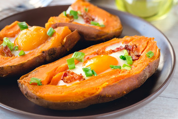Baked sweet potato with fried egg, bacon and chives.