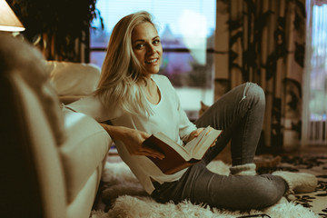 Beautiful blond  caucasian woman reading an amusing book on a wh