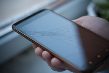 man hand hold and touch screen smartphone or cellphone isolated on white , with crack or broken screen.