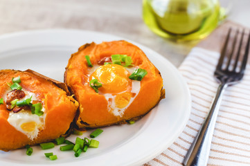 Baked sweet potato with fried egg, bacon and chives.