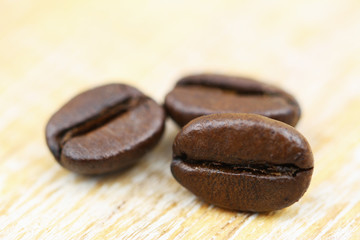 Macro of roasted coffee beans on wooden surface
