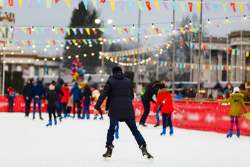 Obraz premium People winter friendship sport and leisure concept happy friends ice skating on rink outdoors