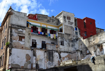 reste eines abgebrochenen Haus, im hintergrund ist der bewohnte Hausteil zu sehen, frisch gestrichen und mit gewaschener Wäsche  in Havanna auf Kuba