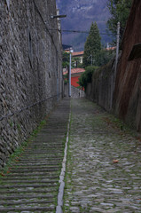 steep cobblestone alley with stairs of an ancient mountain village of Como Lake