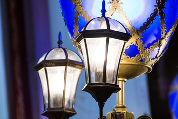 Vintage street lights at night with blue patterned scenery.