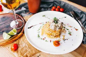 beautifully served crisp potato gratin with a crust of parmesan cheese and a glass of white wine
