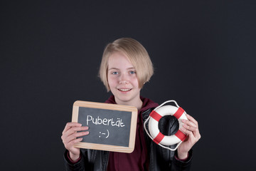 Junges Mädchen mit einer Tafel auf der Pubertät steht und einem Rettungsring in der Hand