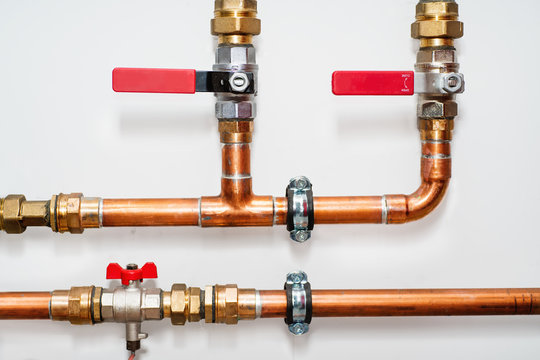 Copper pipes and valves on a white wall