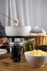Mann isst klassisches Käse Fondue mit Brot und Käseplatte