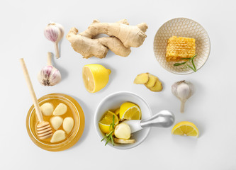 Composition with honey and garlic as natural cold remedies on white background, top view