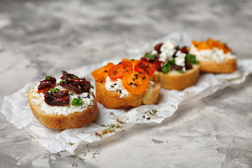 Tasty bruschettas with tomatoes on grey background