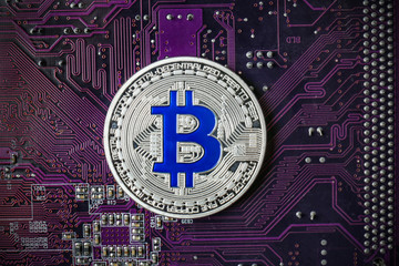 Silver bitcoin on circuit board