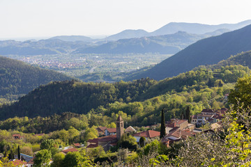 Small italian village in the hills of the northern tuscany area. View upon church and rooftops of the village in the valley. higway in the background.