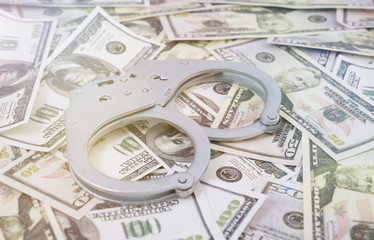 handcuffs on the background of monetary denominations. dollars. economic crime