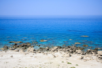Rocky beach and blue clear sea and sky