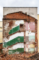 Fragment of the facade after the dismantling of the building. Dismantling the house. A ruined building. Picturesque remains of the building. Traces on the firewall. Old building.