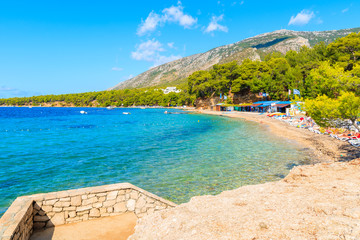 Fototapeta premium BOL TOWN, BRAC ISLAND - SEP 13, 2017: Steps to beautiful beach near famous cape Zlatni Rat in Bol town, Brac island, Croatia.