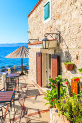 Small coastal restaurant on beach in Bol town, Brac island, Croatia - obrazy, fototapety, plakaty
