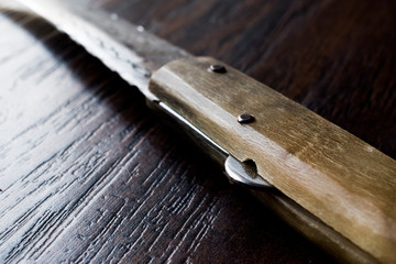 Handmade Wooden Pocket Knife on Dark Surface.