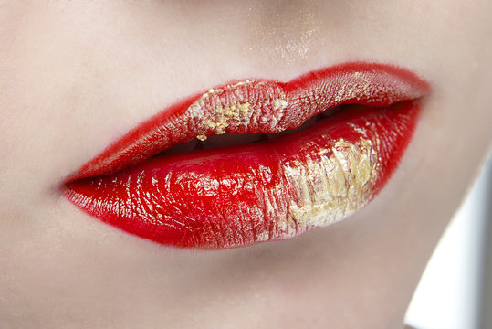 Lips with red lipstick and a Golden element close-up