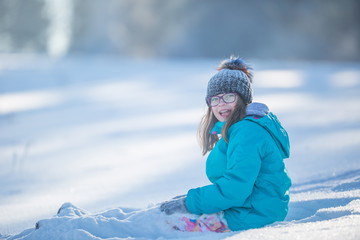 Fototapeta na wymiar Happy young Pre-Teen girl in warm clothing playing with snow