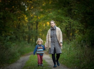 Fototapeta premium Mother and son together in forest. Family in autumnal forest.